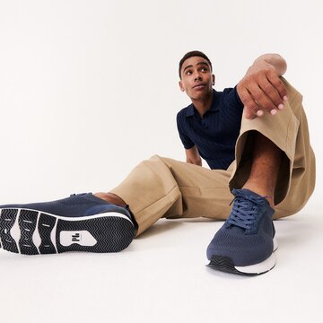 Gabor Herrenschuhe | Eine männliche Person sitzt auf dem Boden, trägt blaue Sneaker mit weißer Sohle - Frühjahr/Sommer 2026 | © Gabor Shoes GmbH, Rosenheim