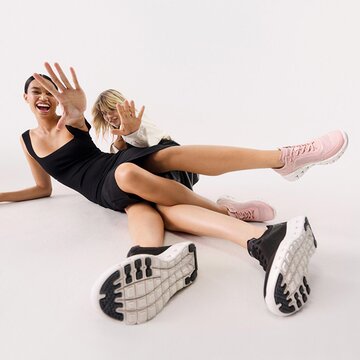 Chaussures femme Gabor | Deux femmes allongées au sol, focus sur des baskets sportives rose et noires à semelle blanche – Printemps/Été 2026 | © Gabor Shoes GmbH, Rosenheim