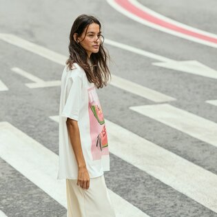 Une femme traverse un passage piéton et porte un t-shirt blanc avec un imprimé coloré ainsi qu’un pantalon clair. La rue présente des marquages voyants. | © Gabor Shoes GmbH, Allemagne