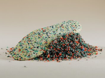 Une semelle de recyclage colorée et du matériau de recyclage en vrac sont posés sur une surface claire. | © Gabor Shoes GmbH, Allemagne