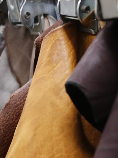 Plusieurs morceaux de cuir de différentes couleurs sont suspendus en rangée, triés par des pinces métalliques. | © Gabor Shoes GmbH, Allemagne
