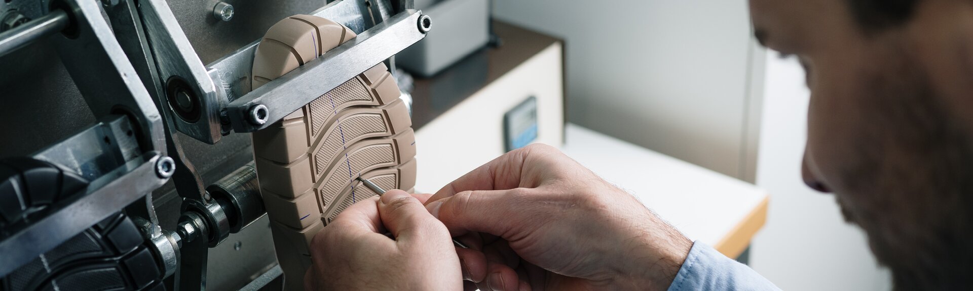 Gros plan sur des mains qui travaillent une semelle de chaussure claire à un dispositif métallique. | © Gabor Shoes GmbH, Allemagne