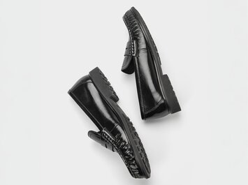 Svarta damloafers i blankt läder med profilerad sula, frilagda mot vit bakgrund. | © Gabor Shoes GmbH, Tyskland