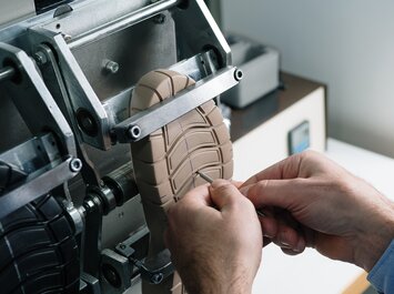 Deux mains vérifient la semelle d’une chaussure dans une machine. | © Gabor Shoes GmbH, Allemagne