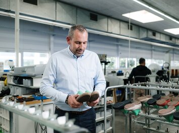 Person inspects shoe soles in a factory. | © Gabor Shoes GmbH, Germany