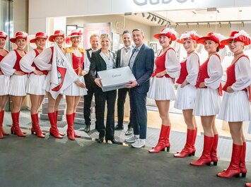"A group of people with carnival dancers in red costumes and Gabor gift boxes. " | © Gabor Shoes GmbH, Germany