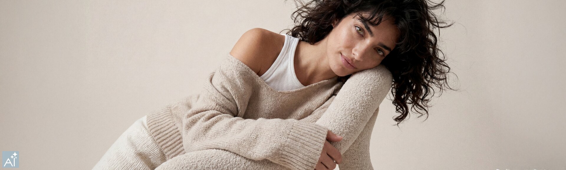 Une image générée par IA montrant une jeune femme assise de manière détendue, portant un ensemble en maille beige et un haut blanc, la tête appuyée sur un dossier de chaise. | © Gabor Shoes GmbH, Allemagne