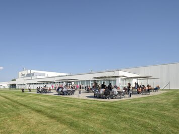 Des personnes sont assises et debout sur une terrasse devant un bâtiment Gabor. | © Gabor Shoes GmbH, Allemagne